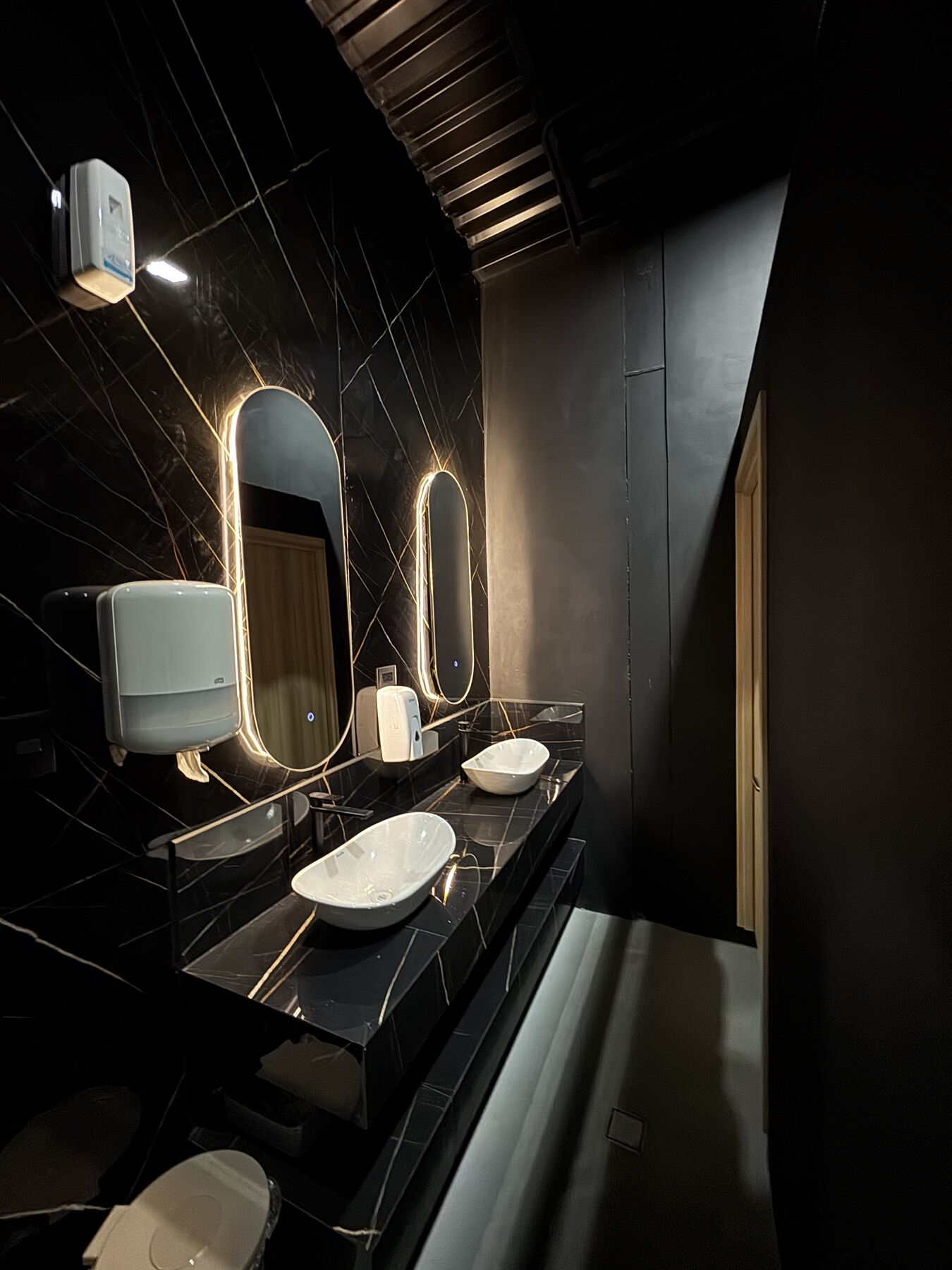 Baño con espejos iluminados · Restaurante Fuego y Brazas